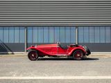 a red vintage car parked on the side of the road