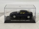 a black toy car in a clear box on a table