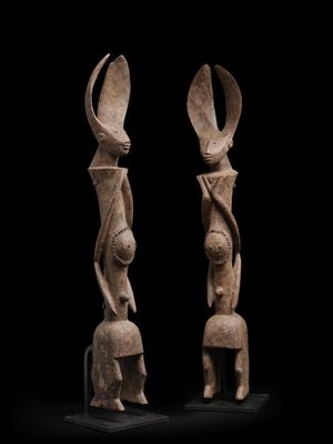 une paire de figurines en bois sculpté représentant une femme et un homme