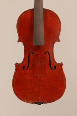 an old violin sitting on top of a white surface