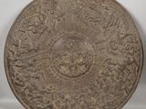 an old metal plate sitting on top of a white surface