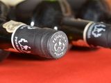 several bottles of wine are lined up on a red table