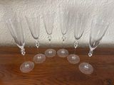 several empty wine glasses are lined up on a wooden table
