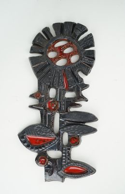 an image of a metal wall decoration with a red and black design