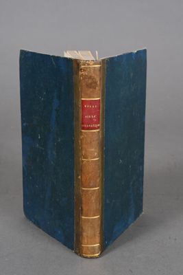 an old book with a blue cover sitting on a table