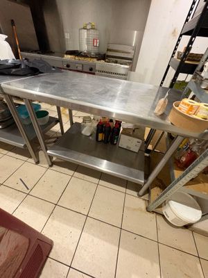 une grande table en acier inoxydable au milieu d'une cuisine