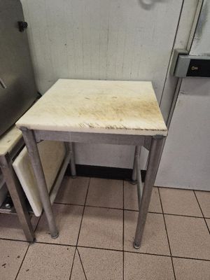 un sol carrelé dans une cuisine avec une petite table et un réfrigérateur