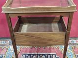 a small wooden table with a glass top on a rug