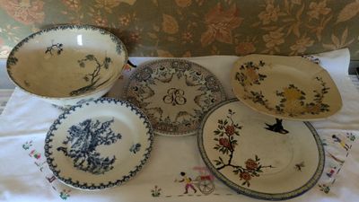 many plates and bowls sitting on a white table cloth