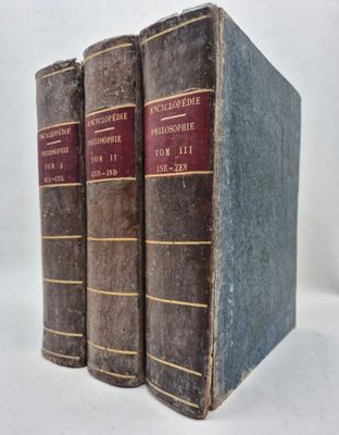 three old books sitting on top of each other on a white surface