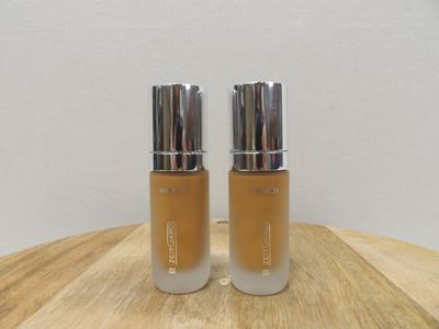 two bottles of liquid sitting on top of a wooden table
