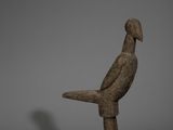une image représentant une statue d'oiseau posée sur un bloc de bois