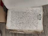 an old book sitting on a wooden floor next to a toilet