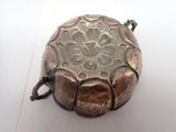 a small metal object that is on a white surface