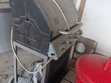 an image of an outdoor kitchen with a grill and a trash can