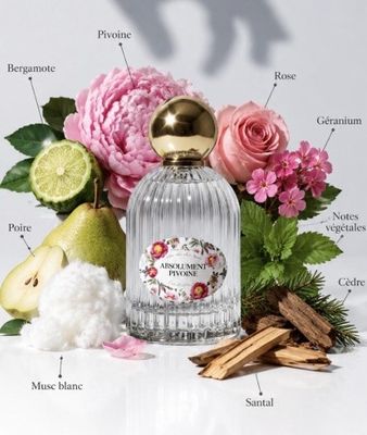 an image of a bottle of perfume surrounded by flowers and fruit
