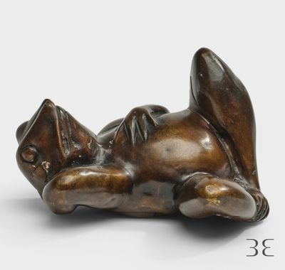 une photo d'une sculpture en bronze représentant un chat couché sur le dos