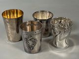 three silver cups with designs on them sitting next to each other