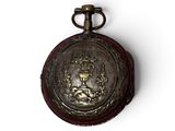 an old pocket watch with a crown on it on a white surface