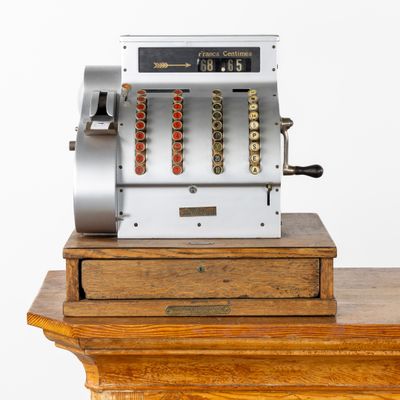 une caisse enregistreuse à l'ancienne posée sur une table en bois