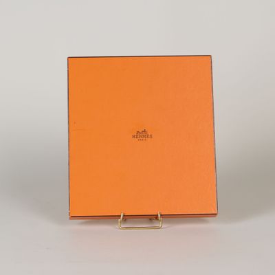 une boîte orange avec une poignée dorée sur un fond blanc