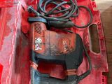 a red tool box with a drill and a cord in it