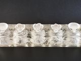 une image représentant un bougeoir en verre transparent contenant quatre bougies