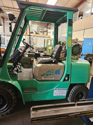 un chariot élévateur vert garé dans un garage