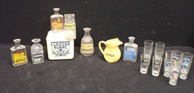 Des bouteilles et des verres sont alignés sur une table, à côté d'un pichet et d'un autre pichet.