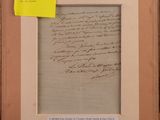 an old handwriting on a piece of paper in a wooden frame