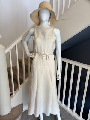 mannequin vêtu d'une robe blanche et d'un chapeau de paille, posé sur un escalier