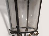 a black lantern hanging from a wall on a white background