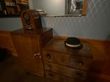 a dresser with a hat on top of it in a room