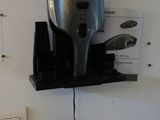 un sèche-cheveux accroché au mur à côté d'une prise électrique