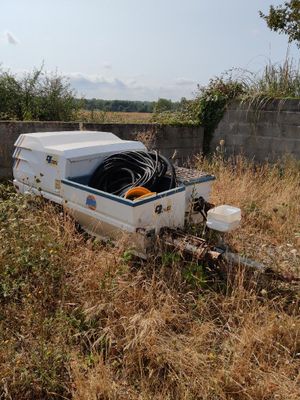 a white boat sitting in the middle of a field