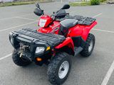 an image of a red four wheeler atv in a parking lot