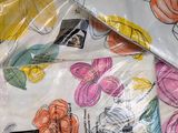 many bags of fabric with flowers on them on a table
