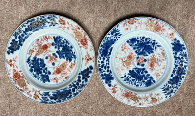deux assiettes bleues et blanches ornées de motifs floraux, posées sur un support marron