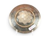 a silver plate with a gold medallion on it