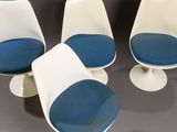 three white and blue chairs sitting next to each other on a table