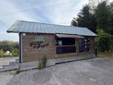 un petit bâtiment en bois sur lequel est accrochée une enseigne