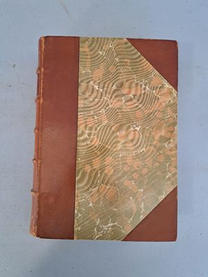 un vieux livre à la couverture marron posé sur une table