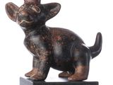 statue d'un chat coiffé d'un chapeau, posée sur un socle en bois