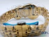 an image of a gold watch with a blue band on a white surface