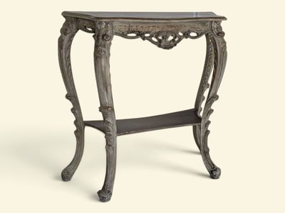 une console richement sculptée, dotée d'une étagère en dessous