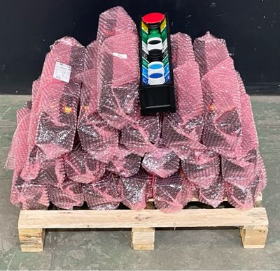 une pile de sacs en plastique roses posée sur une palette, avec une canette de soda à côté