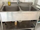deux éviers dans la cuisine avec un tapis noir