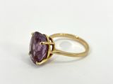 a close up of a gold ring with a purple stone