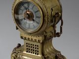 une horloge en or posée sur un socle