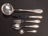 five spoons and a spoon with a spoon rest on a table